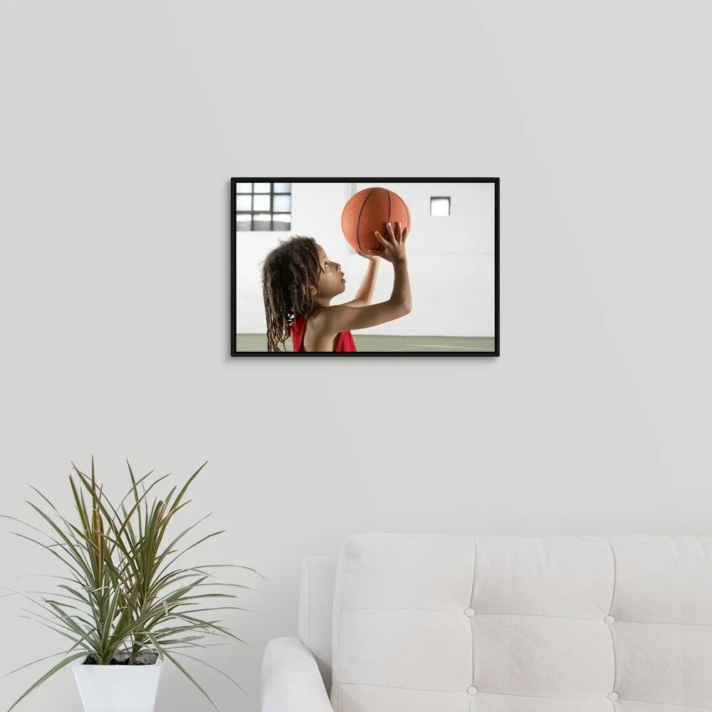 "Boy aiming a shot with a basketball in a school sports hall." Black Float Frame Canvas Art