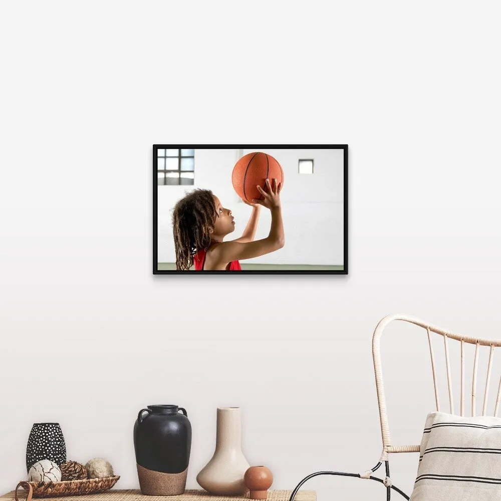 "Boy aiming a shot with a basketball in a school sports hall." Black Float Frame Canvas Art