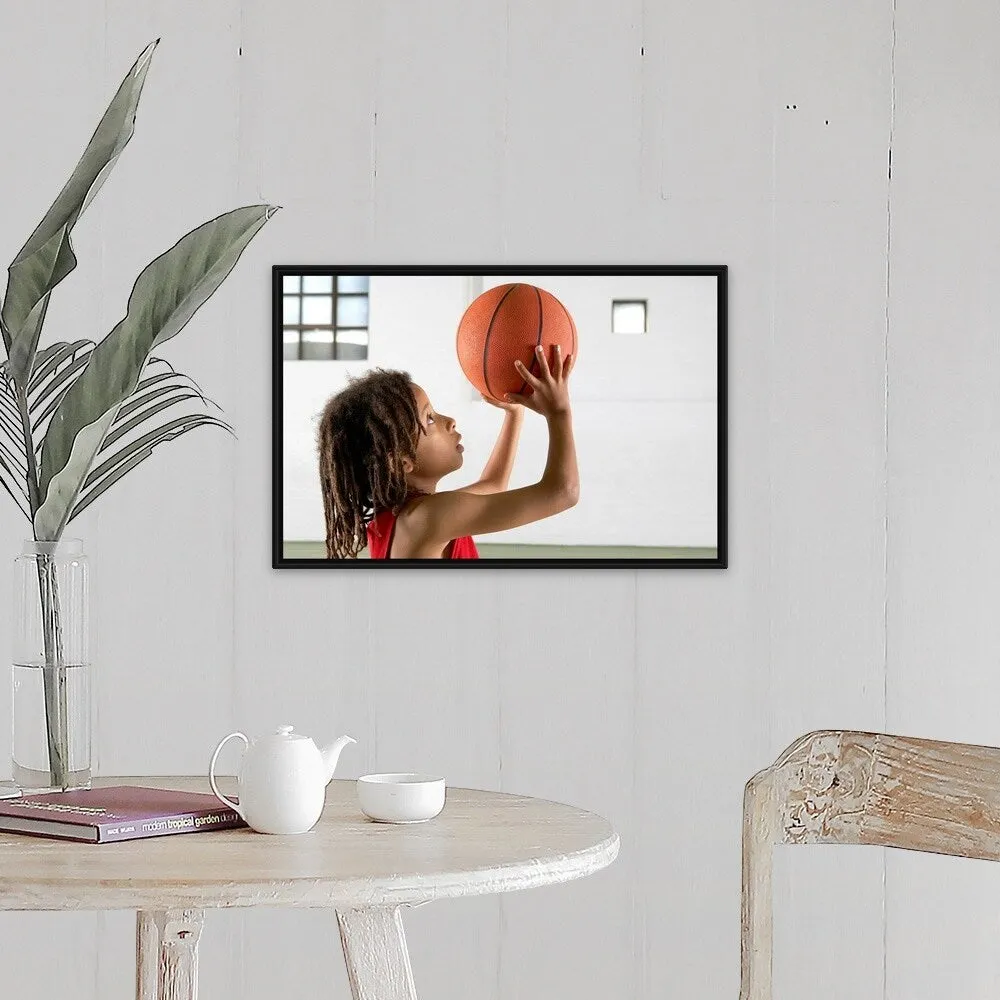 "Boy aiming a shot with a basketball in a school sports hall." Black Float Frame Canvas Art